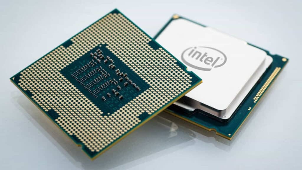 Two Intel processors, one with its underside circuitry exposed and the other with its branding visible, lying on a white surface.