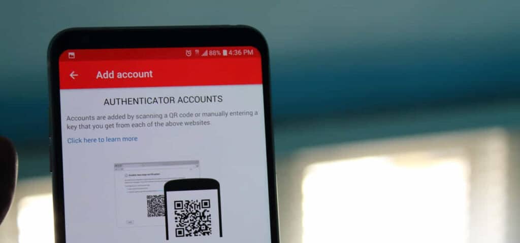 A smartphone displaying an 'Add Account' screen for authenticator accounts with an option to scan a QR code or enter a key manually.